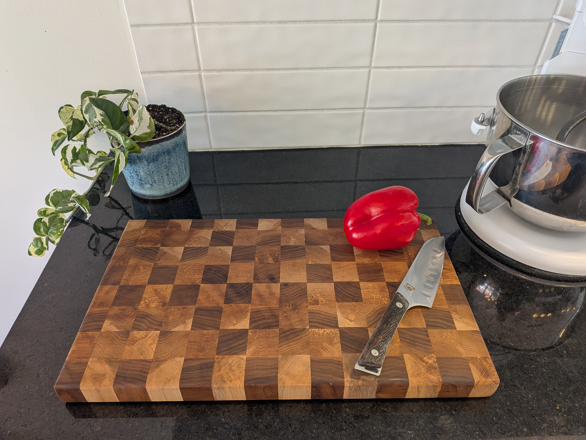 Planche damier avec poignées, mise en scène avec poivron rouge